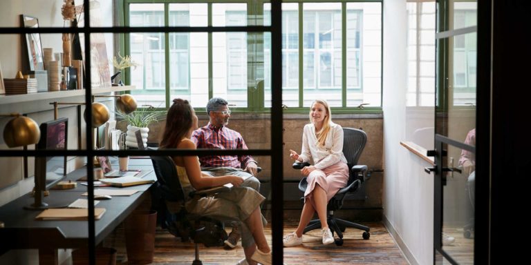 Team meeting between a team of three business professionals in a brightly lit office, Caber Hill Advisors