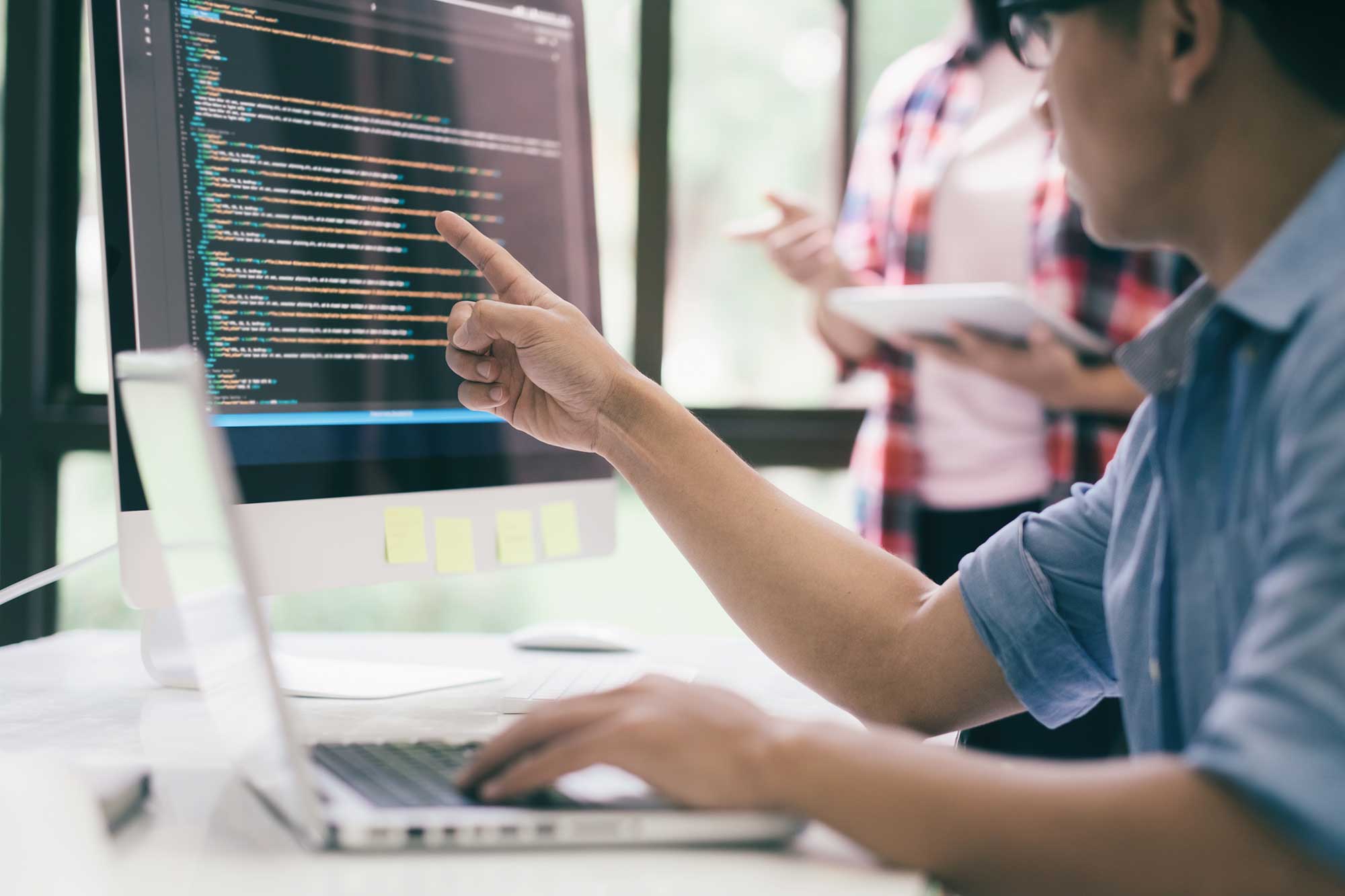 Data-Meeting A pair of professionals examining data on a desktop computer, one is examining the computer while one is taking notes, Caber Hill Advisors