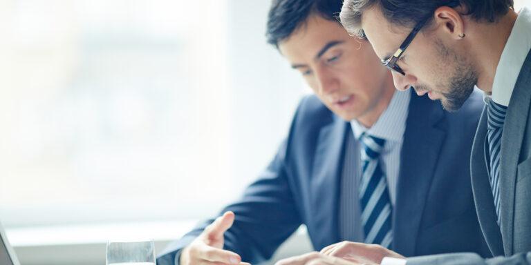 Businessmen discussing work during a meeting at office, Caber Hill Advisors