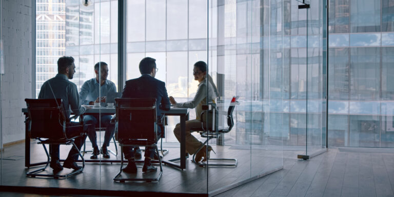 A meeting between five business professionals in a glass meeting room overlooking a city skyline, Caber Hill Advisors