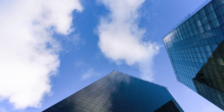 Two glass skyscrapers seen from below