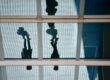 Silhouette of two people outside of a glass office building