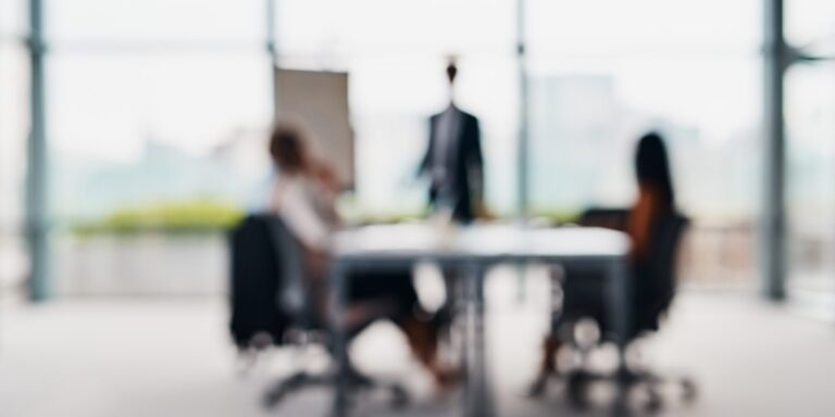 Blurred shot of corporate businesspeople having a meeting in the boardroom.